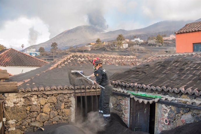 Efectivos de Emergencias usando las pértigas diseñadas para la retirada de ceniza en La Palma.