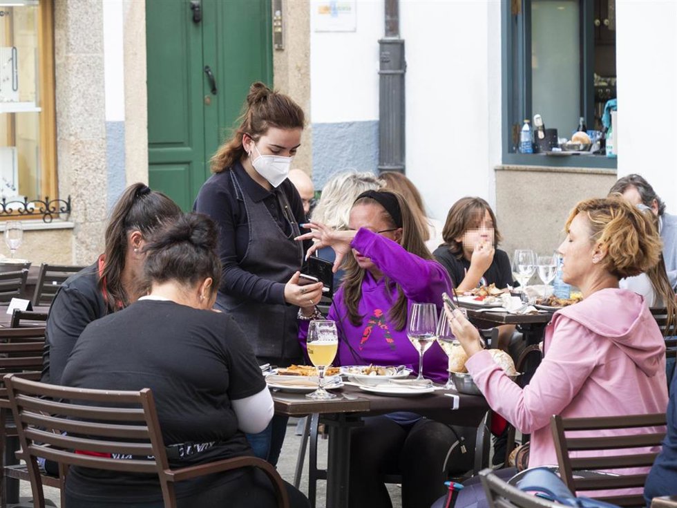 Archivo - Varias personas en la terraza de un bar.