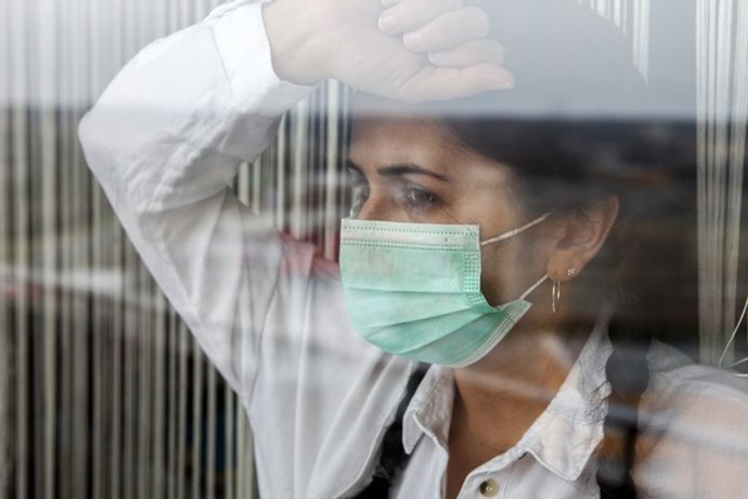Archivo - Mujer en la ventana guardando cuarentena en casa.