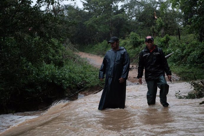 Archivo - 17 November 2020, Nicaragua, Siuna: Two men wade through the waters of an overflowing river after the devastating hurricane Iota made landfall in Nicaragua. Photo: Carlos Herrera/dpa