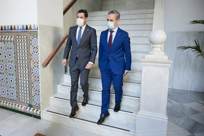 El consejero de Hacienda y Financiación Europea, Juan Bravo (d) baja las escaleras junto al presidente de la Junta, Juanma Moreno, (i) durante el último debate presupuestario en el Parlamento andaluz el pasado mes de noviembre