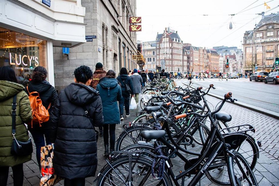 Colas en comercios no esenciales de Ámsterdam en víspera de la entrada en vigor del confinamiento por coronavirus en Países Bajos