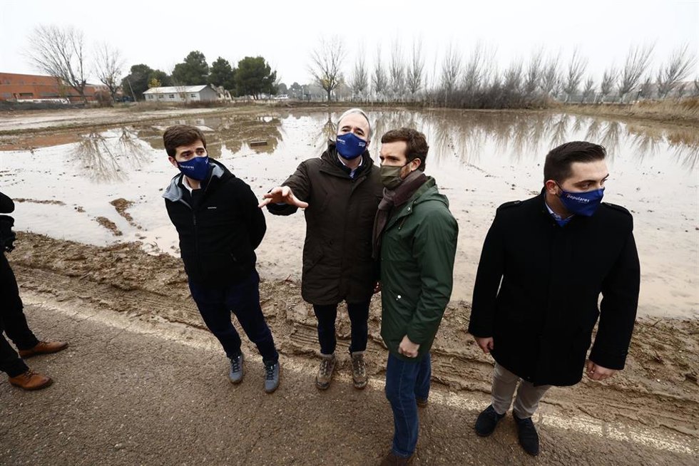 El líder del PP, Pablo Casado (2d), y el alcalde de Zaragoza y presidente del PP de Aragón, Jorge Azcón (2i), durante una visita a una de las zonas afectadas por la crecida del río Ebro, a 19 de diciembre de 2021, en Monzalbarba, Aragón (España). El líd