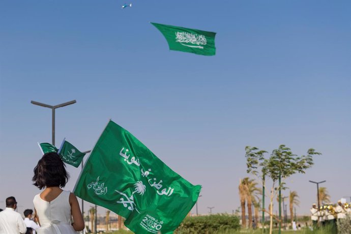 Archivo - 22 September 2021, Saudi Arabia, Riyadh: A Saudi girl watches as a helicopter performs a flyby with a giant Saudi flag during an air show on the occasion of the Saudi National Day. Photo: Mohammed Almsaad/Saudi Press Agency/dpa