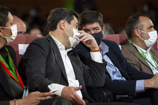 El  presidente de la Junta de Andalucía, Juanma Moreno (i), charla con el  coordinador de Ciudadanos (Cs) en Andalucía y vicepresidente de la Junta, Juan Marín (d) en el  Congreso Autonómico del PP-A en Granada