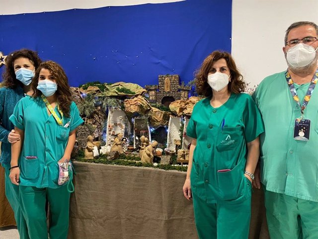 Profesionales sanitarios junto a uno de los belenes ubicados en el Hospital Universitario Reina Sofía.