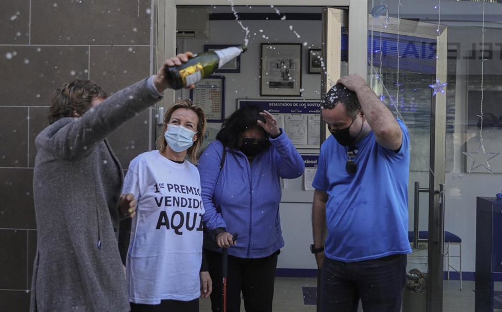 Archivo - Una pareja de agraciados celebran `El Gordo junto a las loteras en la administración de lotería situada en la Avenida de Andalucía en la que se ha repartido parte del número `72.897 correspondiente a 'El Gordo' de la Lotería de Navidad. Punta 