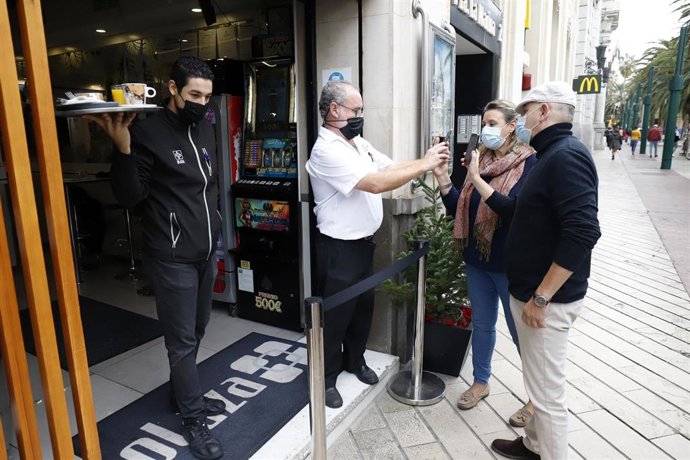 Un camarero pide certificado a los clientes en la puerta de un bar 