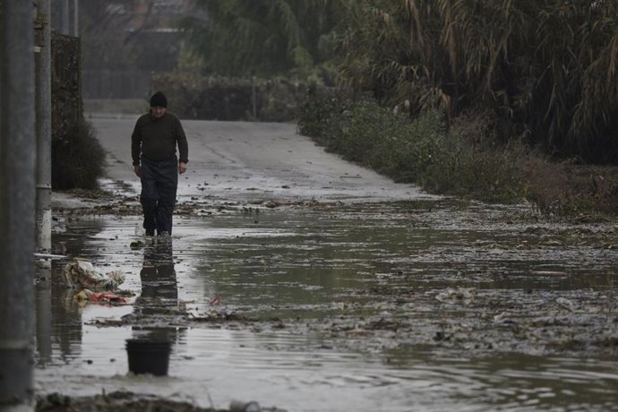 Un hombre camina por una de las carreteras afectadas por la crecida del río Ebro, a 14 de diciembre de 2021, en Buñuel, Navarra (España). 