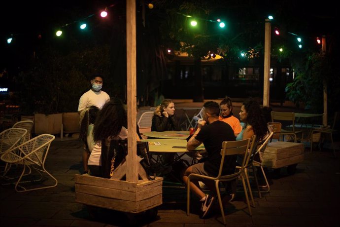 Archivo - Varias personas en la terraza de un bar, frente a la playa de la Barceloneta, a 4 de agosto de 2021