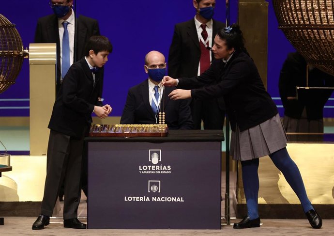 Dos de los niños de la residencia de San Ildefonso que han cantado uno de los quintos premios al número 92.052, durante la celebración del Sorteo Extraordinario de la Lotería de Navidad 2021 