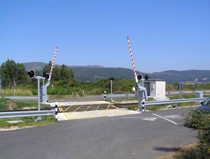 Archivo - Paso a nivel protegido por barreras y señales luminosas