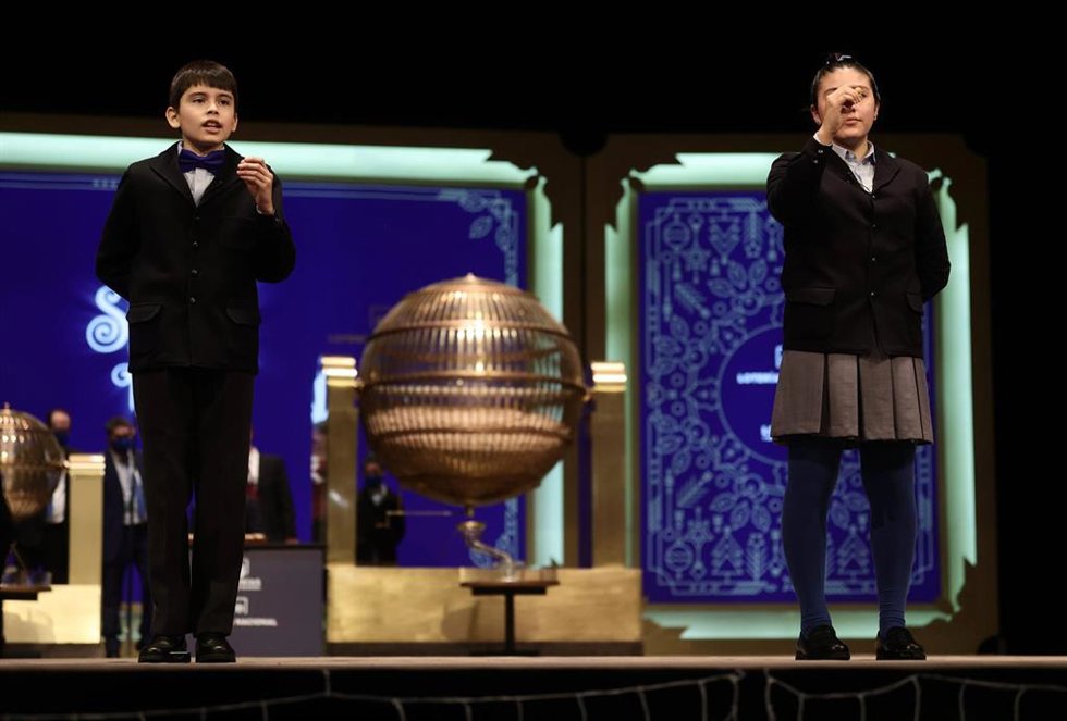 Dos de los niños de la residencia de San Ildefonso cantan uno de los quintos premios al número 92.052, durante la celebración del Sorteo Extraordinario de la Lotería de Navidad 2021 en el Teatro Real de Madrid, a 22 de diciembre de 2021, en Madrid, (Esp