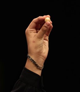 Una de las niñas de la residencia de San Ildefonso sostiene la bola con la que ha cantado uno de los quintos premios al número 70.316, durante la celebración del Sorteo Extraordinario de la Lotería de Navidad 2021 en el Teatro Real de Madrid