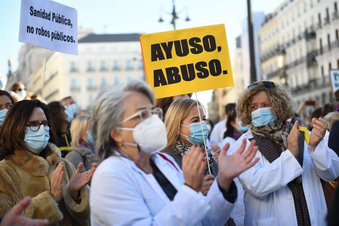 Archivo - Un grupo de personas con un cartel donde se puede "Ayuso, abuso" en una concentración en defensa de la Atención Primaria, a 13 de noviembre de 2021, en Madrid, (España). Convocada por la Asociación de Médicos y Titulados Superiores de la Comun
