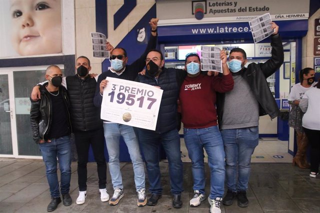 El lotero esús Ibáñez junto a algunos clientes tras repartir 17 series del tercer premio en Almería