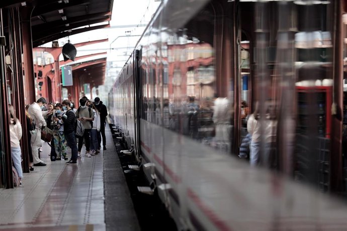 Archivo - Varios pasajeros esperan en uno de los andenes de la estación de Chamartín.