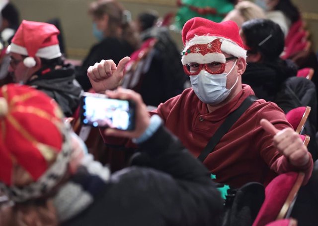 Un hombre disfrazado se hace una fotografía minutos antes del inicio de la celebración del Sorteo Extraordinario de la Lotería de Navidad 2021