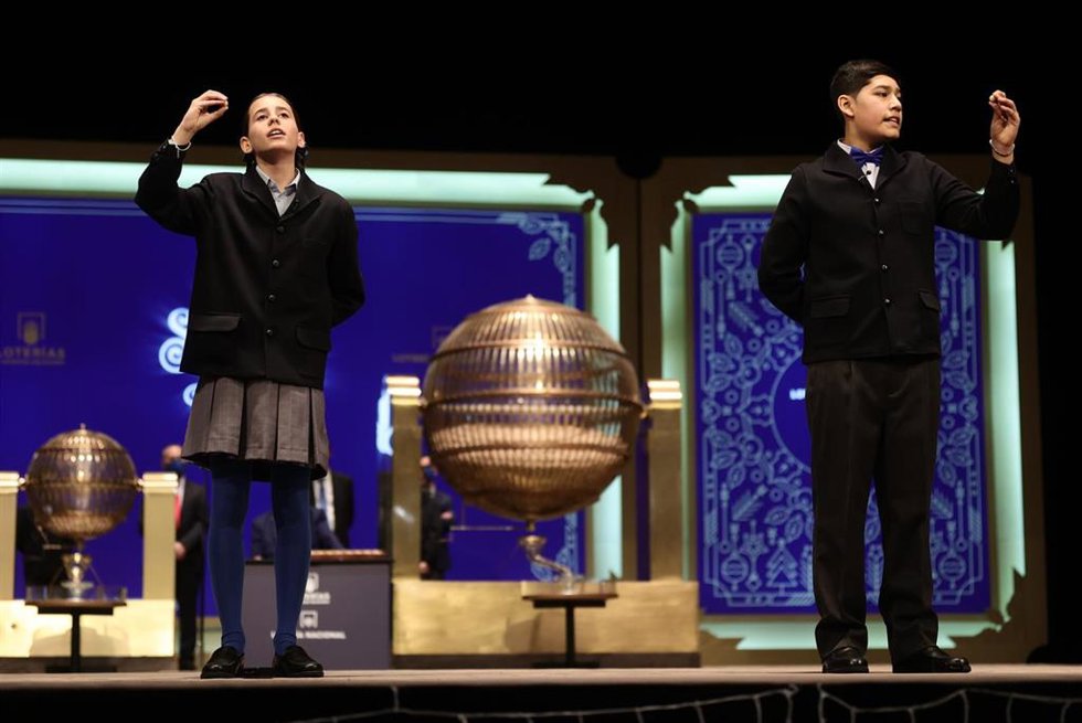 Dos de los niños de la residencia de San Ildefonso cantan uno de los quintos premios durante la celebración del Sorteo Extraordinario de la Lotería de Navidad 2021 en el Teatro Real de Madrid.