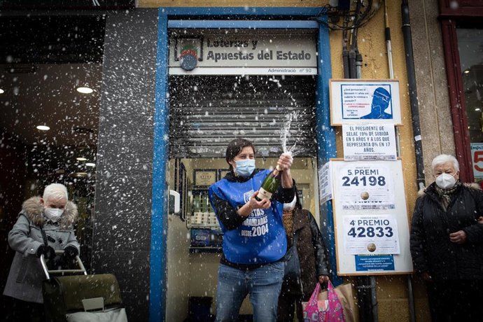 Cristina Palls, propietaria de la administración de Lotería del Paseo Fabra i Puig, 179, de Barcelona celebra con cava que ha repartido el cuarto y quinto premio del Sorteo Extraordinario de la Lotería de Navidad, en la puerta de la administración, que