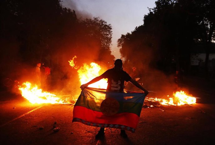 Archivo - Un hombre porta una bandera mapuche 