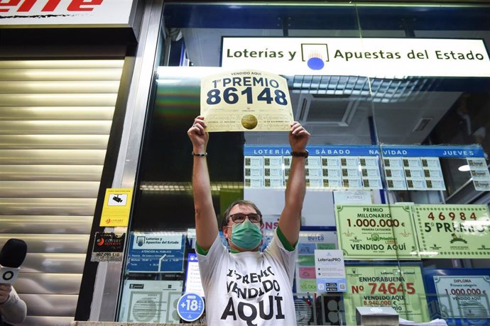 Javier Moñino, empleado de la administración situada en la zona del AVE de la Estación de Atocha, celebra que ha vendido parte del número 86148 correspondiente al  'Gordo' del Sorteo Extraordinario de la Lotería de Navidad, a 22 de diciembre de 2021, en