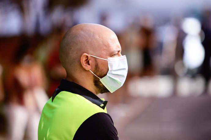 Archivo - Un policía municipal protegido con mascarilla