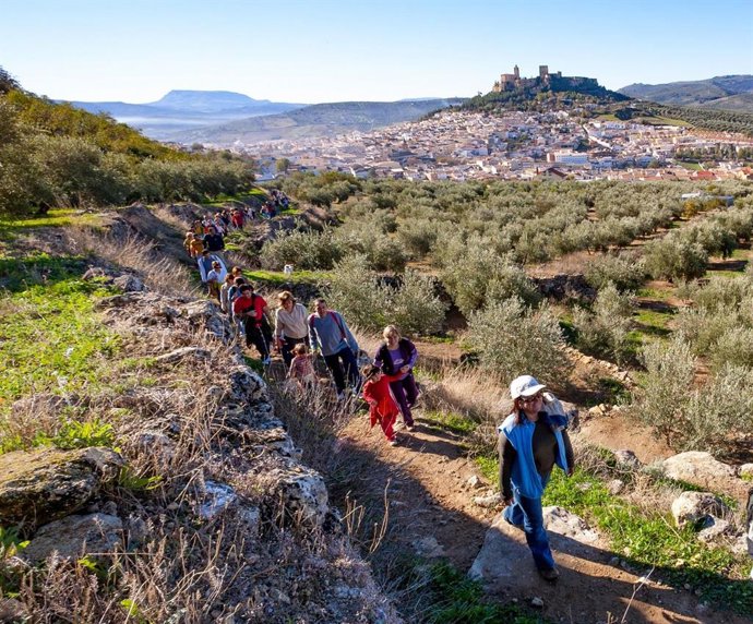 Archivo - Senderistas en Alcalá la Real, con la población y la Fortaleza de La Mota al fondo.