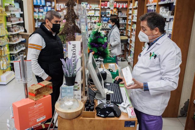 Un hombre recoge en la farmacia de la Calle Tucán, en el distrito de Carabanchel, un test de antígeno gratuito