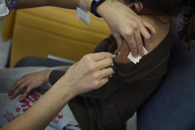 Una niña recibe una dosis de la vacuna contra el Covid-19, en el Hospital La Paz