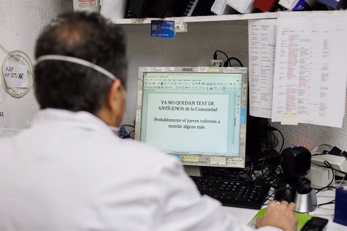 El farmacéutico se dispone a imprimir un cartel para anunciar que los test de antígenos de la Comunidad de Madrid están agotados en la farmacia de la Calle Tucán, en el distrito de Carabanchel, a 21 de diciembre de 2021, en Madrid (España).