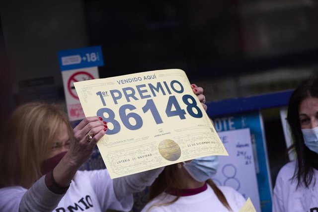 Una de las empleadas de la administración situada en la calle Toledo celebra que han vendido parte del número 86148 correspondiente al  'Gordo' del Sorteo Extraordinario de la Lotería de Navidad, a 22 de diciembre de 2021, en Madrid (España). El sorteo de