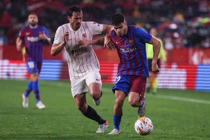 21 December 2021, Spain, Sevilla: Barcelona's Ez Abde (R) and Sevilla's Thomas Delaney battle for the ball during the Spanish La Liga soccer match between Sevilla and Barcelona at Ramon Sanchez-Pizjuan Stadium. Photo: Jose Luis Contreras/DAX via ZUMA Pr