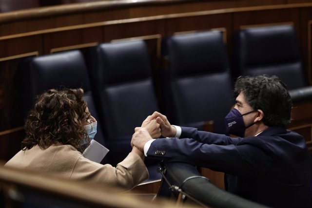 La ministra de Hacienda, María Jesús Montero, y el diputado del PP, Mario Garcés, se saludan en una sesión plenaria en el Congreso de los Diputados, a 23 de diciembre de 2021, en Madrid, (España). Durante el Pleno han debatido sobre varios Proyectos de Le