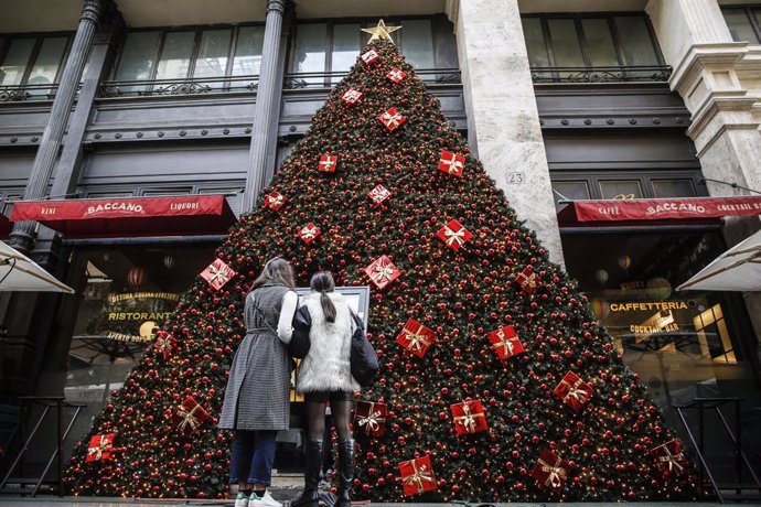 Archivo - 22 November 2021, Italy, Rome: People look at a decorated Christmas tree in the centre of Rome. Italy is experiencing another wave of the coronavirus disease (COVID-19) pandemic. Photo: Fabio Frustaci/ANSA via ZUMA Press/dpa