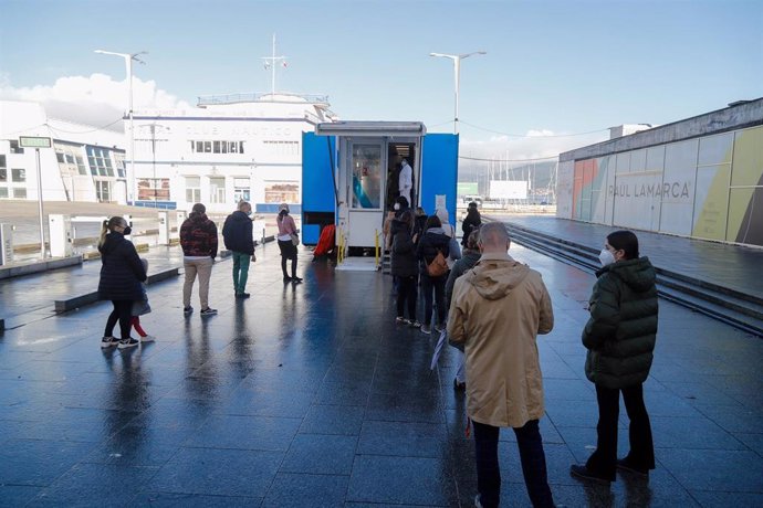 Varias personas hacen cola para hacerse PCR, en un punto móvil de PCR gratuitas en el Naútico de Vigo, a 23 de diciembre de 2021, en Vigo, Pontevedra, Galicia (España). Decenas de personas han hecho más de tres horas de cola desde esta madrugada para ha