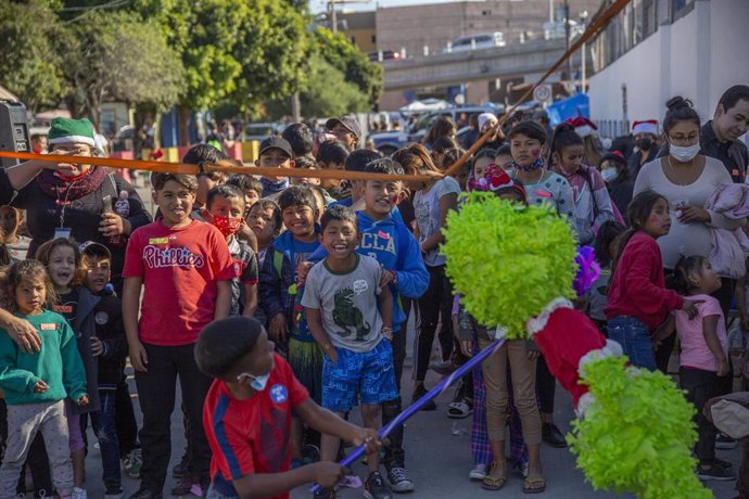 Varios niños migrantes reciben regalos por Navidad en Tijuana, ciudad fronteriza en México. 