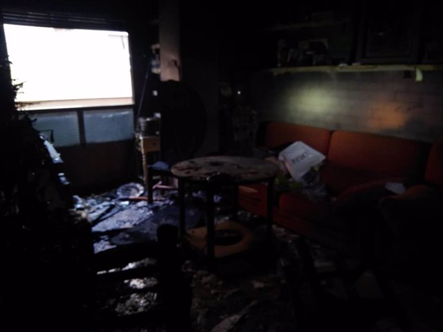 Foto facilitada por Bomberos del Consorcio donde se muestra el estado en que ha quedado el salón de la vivienda tras el incendio