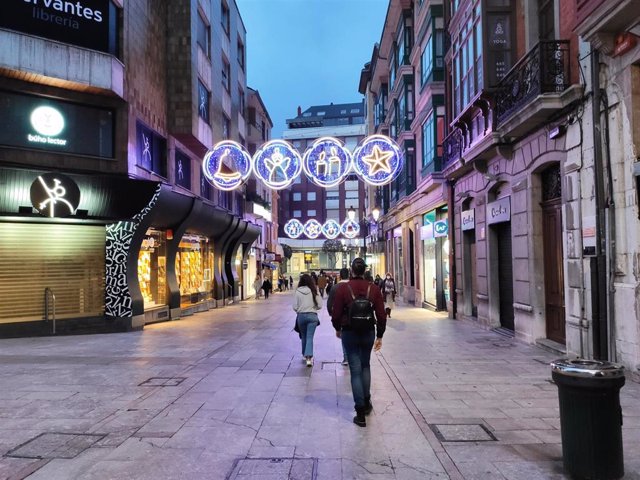 Personas caminando por Oviedo en Navidad.