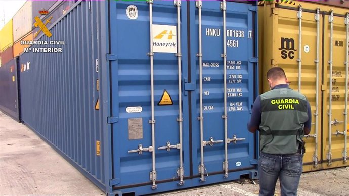 Archivo - Un agente de la Guardia Civil inspecciona un contenedor.