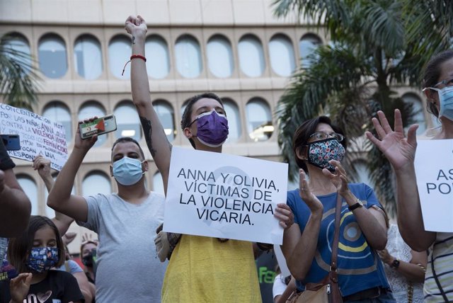 Archivo - Un mujer con un cartel en el que se lee: `Anna y Olivia, víctimas de violencia vicaria, participa en una concentración feminista en Tenerife.