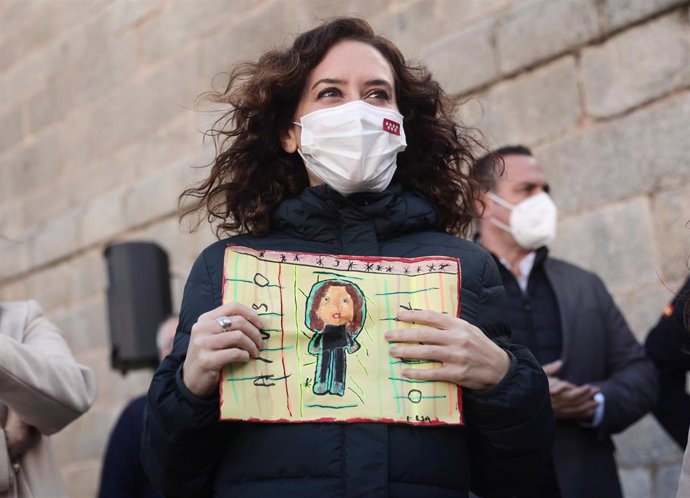 La presidenta de la Comunidad de Madrid, Isabel Díaz Ayuso, sostiene un dibujo durante su visita a San Martín de Valdeiglesias, a 27 de diciembre de 2021, en San Martín de Valdeiglesias, Madrid, (España). Durante su visita ha participado en alguna de la