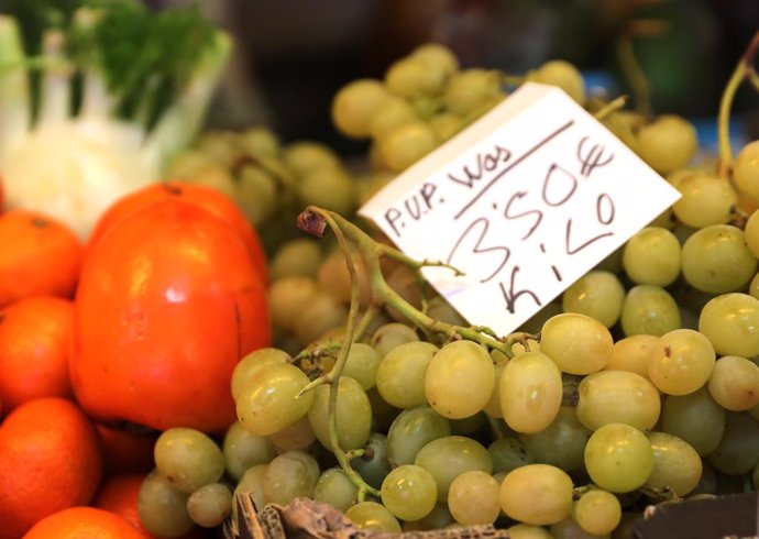 Uvas y caquis en el Mercado de San Isidro, a 17 de diciembre de 2021, en Madrid, (España). El de San Isidro es uno de los mercados municipales que abastecen de alimentos a los madrileños. Según un estudio de la OCU, el español medio podría gastar hasta 