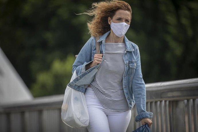 Archivo - Una mujer camina durante el aviso amarillo activado por la Agencia Estatal de Meteorología (Aemet)