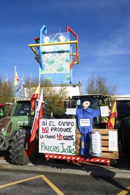 Un tractor sostiene un palé con una pancarta en la que se lee "Si el campo no produce, la ciudad no come", durante una manifestación de profesionales de la ganadería, a 12 de diciembre de 2021, en Santander.