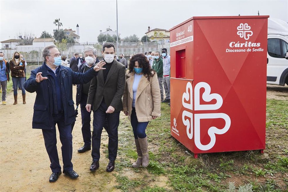 El presidente de la Junta, Juanma Moreno, este lunes junto al presidente de Cáritas Sevilla, Mariano Pérez de Ayala, la consejera de Igualdad, Rocío Ruiz, y detrás de ellos, el alcalde de Dos Hermanas, Francisco Toscano.