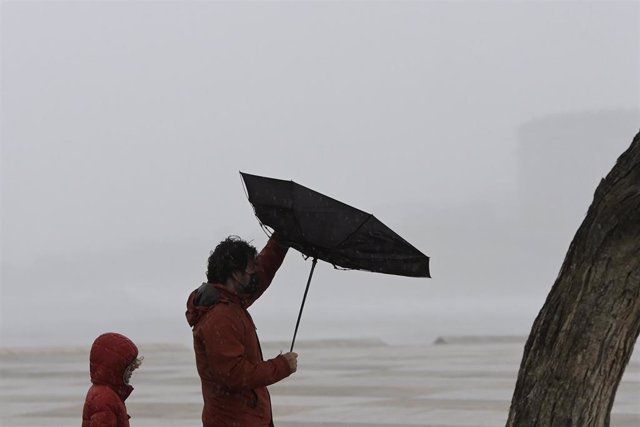Dos personas caminan en la zona de las Esclavas, a 8 de diciembre de 2021, en A Coruña, Galicia, (España). La borrasca Barra ha hecho que la Xunta haya activado para todo el litoral gallego una alerta naranja por temporal costero. Según las previsiones de