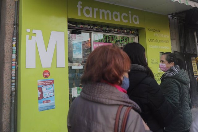 Varias personas hacen cola en una farmacia para adquirir un test de antígenos, a 23 de diciembre de 2021, en Madrid, (España). 