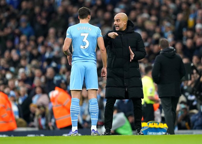 26 December 2021, United Kingdom, Manchester: Manchester City's manager Pep Guardiola (R) speaks with Ruben Dias on the touchline during the English Premier League soccer match between Manchester City and Leicester City at the Etihad Stadium. Photo: Mar