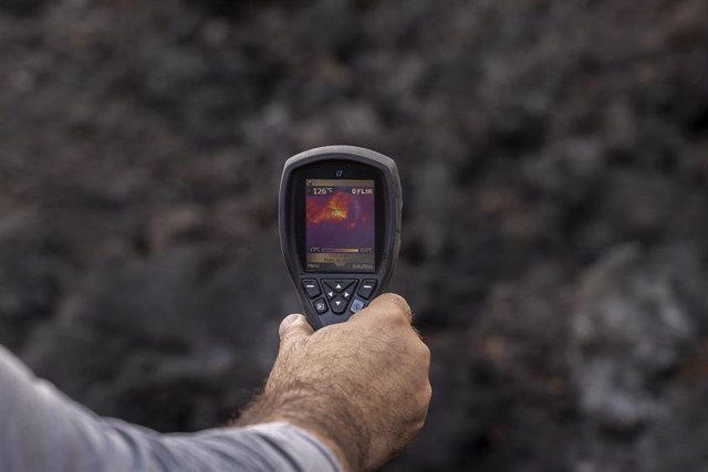 Un hombre mide la temperatura de una colada de lava, en la zona de exclusión próxima al volcán de Cumbre Vieja. 